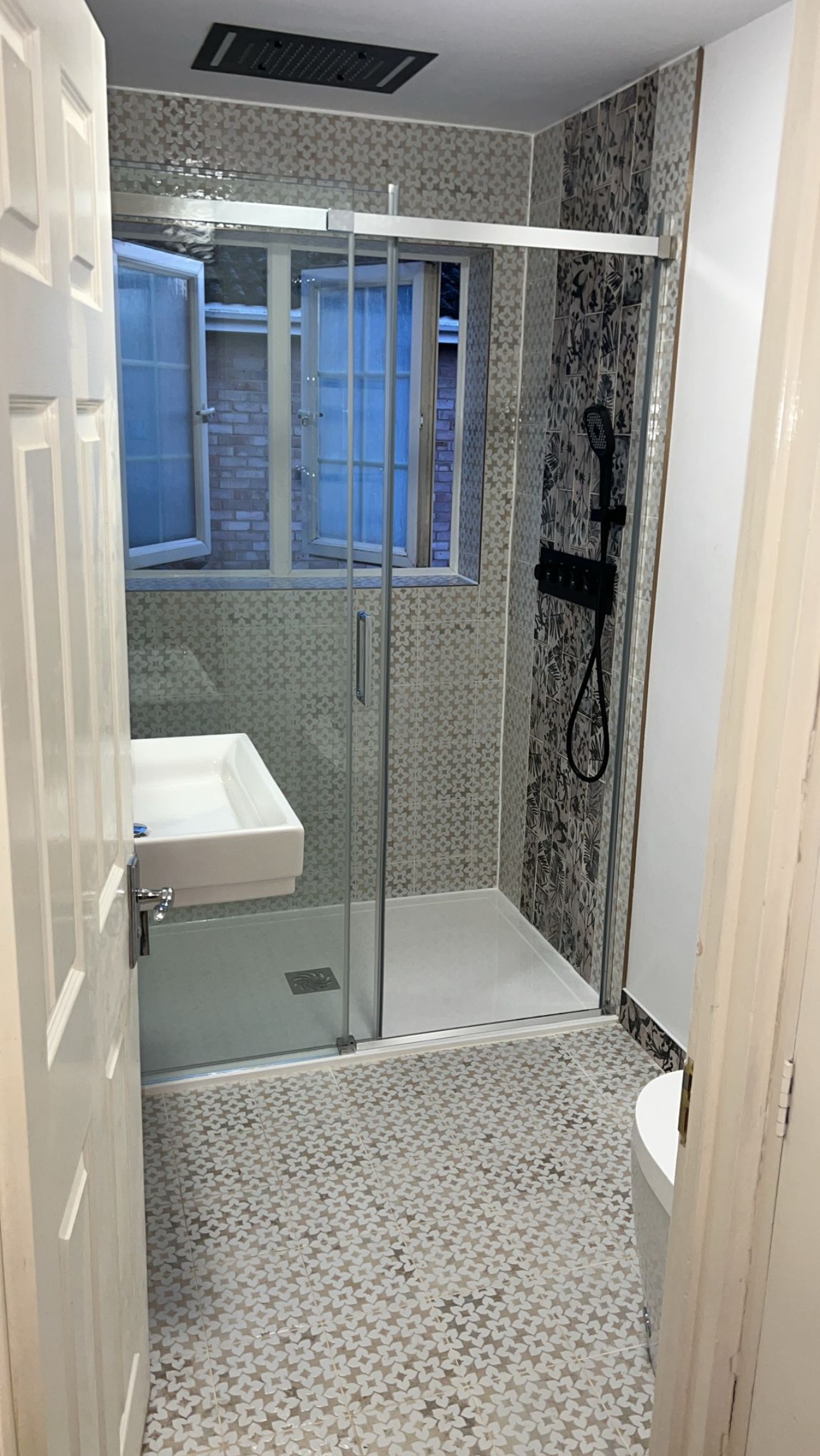 Finished shower room with a glass walk-in shower and patterned floor tiles